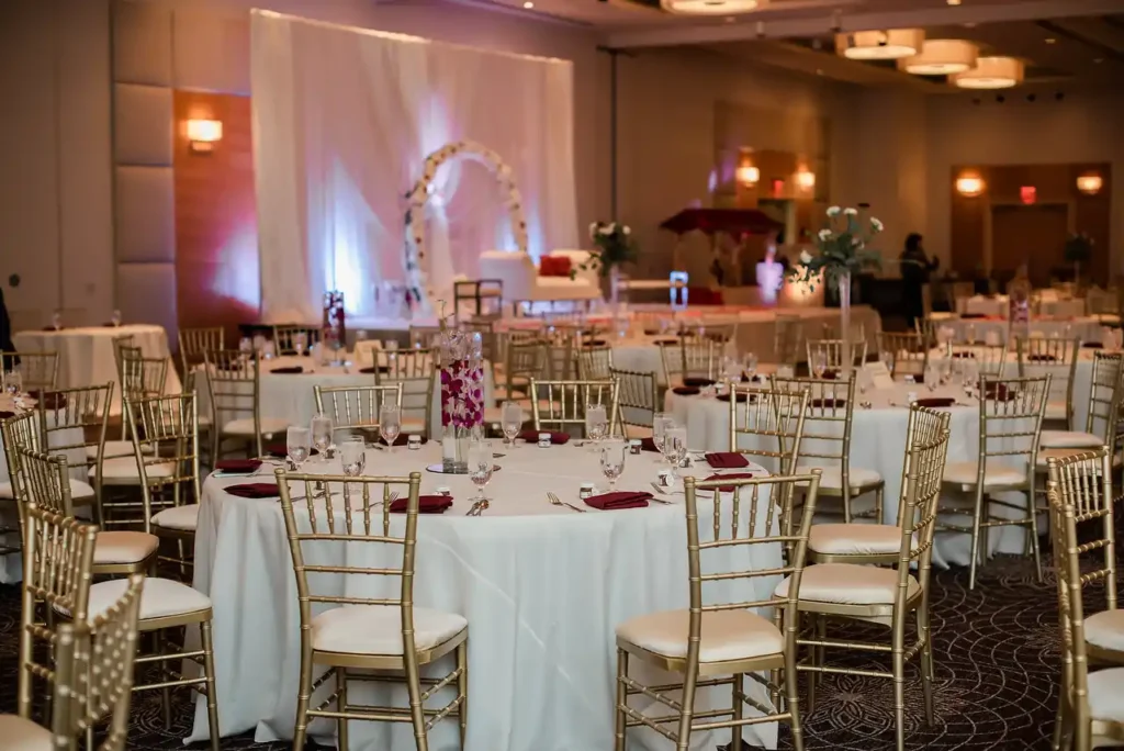 ballroom reception hall orchid centerpieces gold chairs