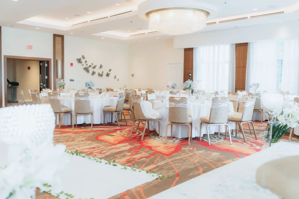 bright reception hall white tables floral carpet