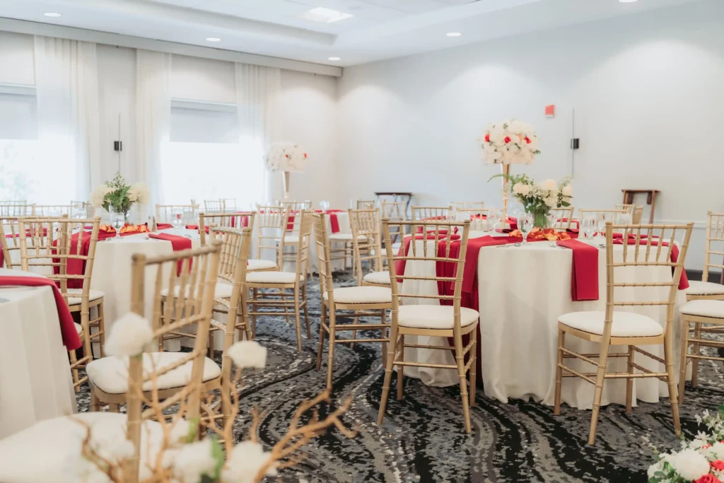 bright reception room red napkins white rose centerpieces