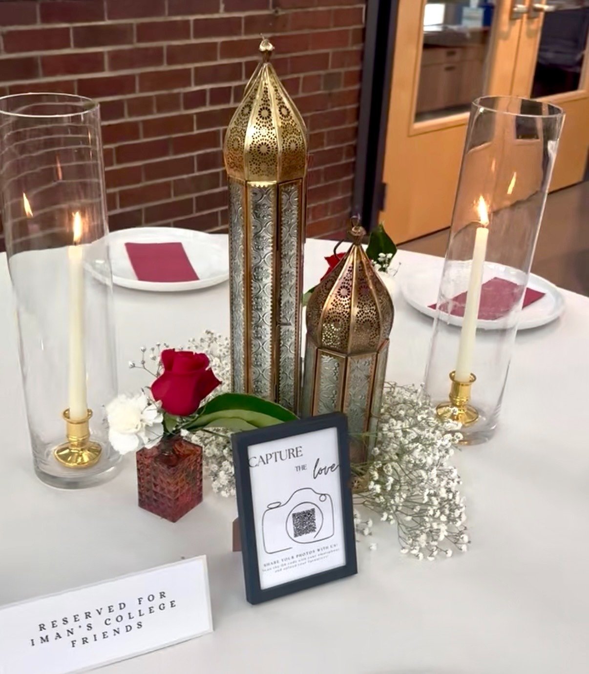 Table decor with Moroccan lanterns, baby's breath, and a sign reading "Reserved for Iman's College Friends