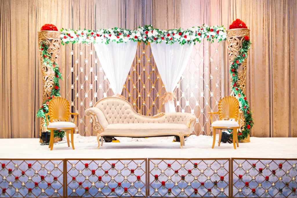 wedding stage ivory chaise gold pillars red white flowers