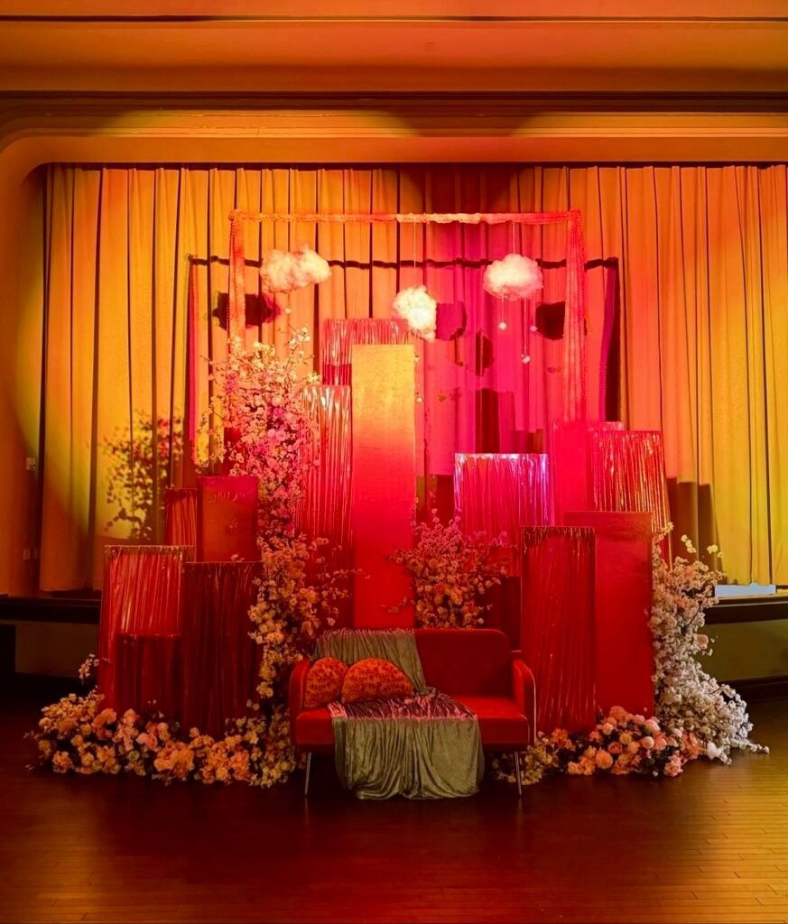Sangeet stage with pink drapes and floral installations by Regal Event Decor