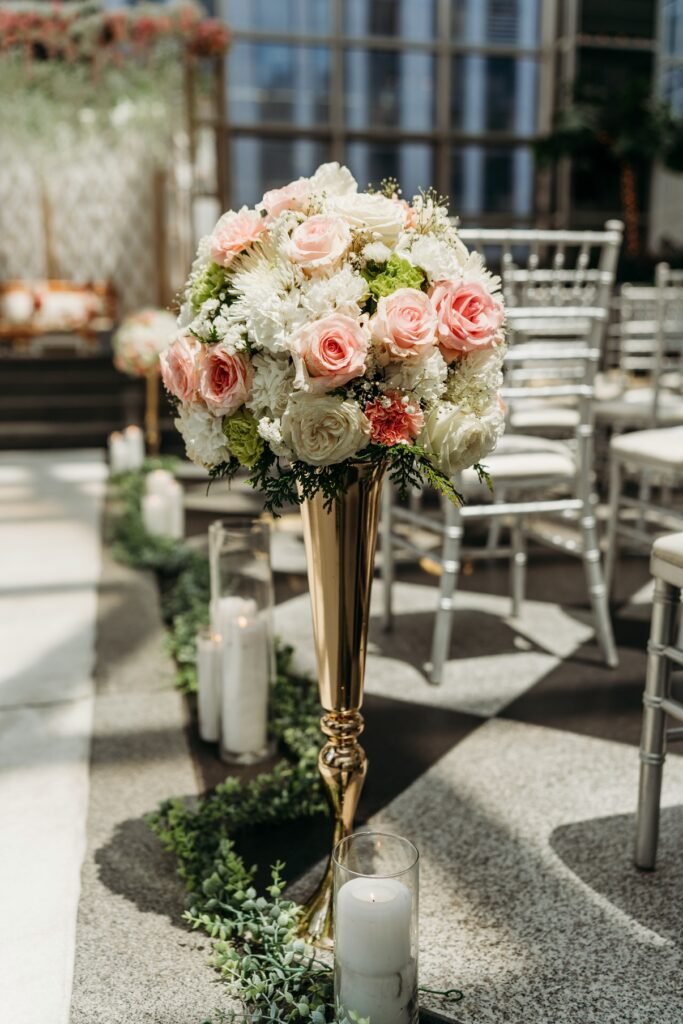 Glass atrium wedding ceremony with blush floral stage by Regal Event Decor