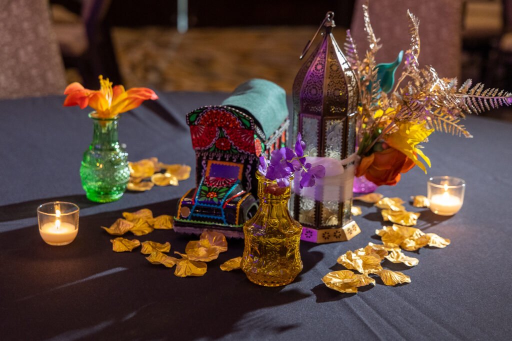 Colorful sangeet table decor Pittsburgh — hand-painted truck art centerpiece, lanterns and marigolds, fusion wedding decor