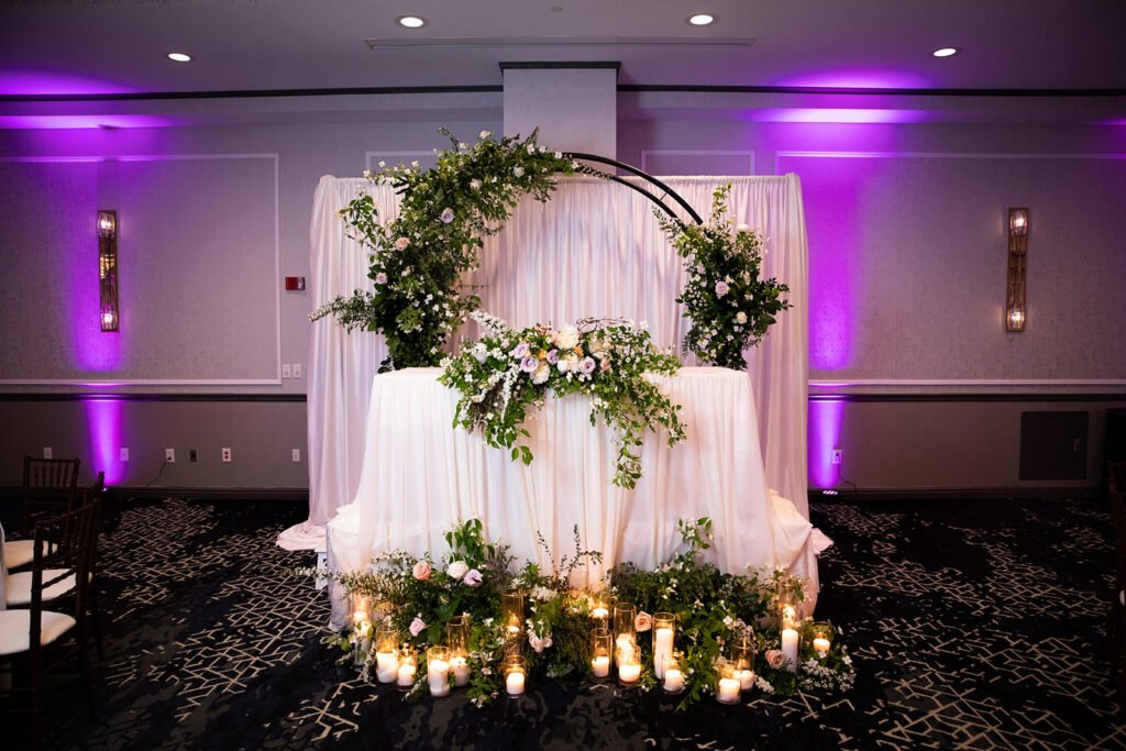 Elegant sweetheart table decor Pittsburgh — floral ring arch over sweetheart table with candles, luxury wedding design