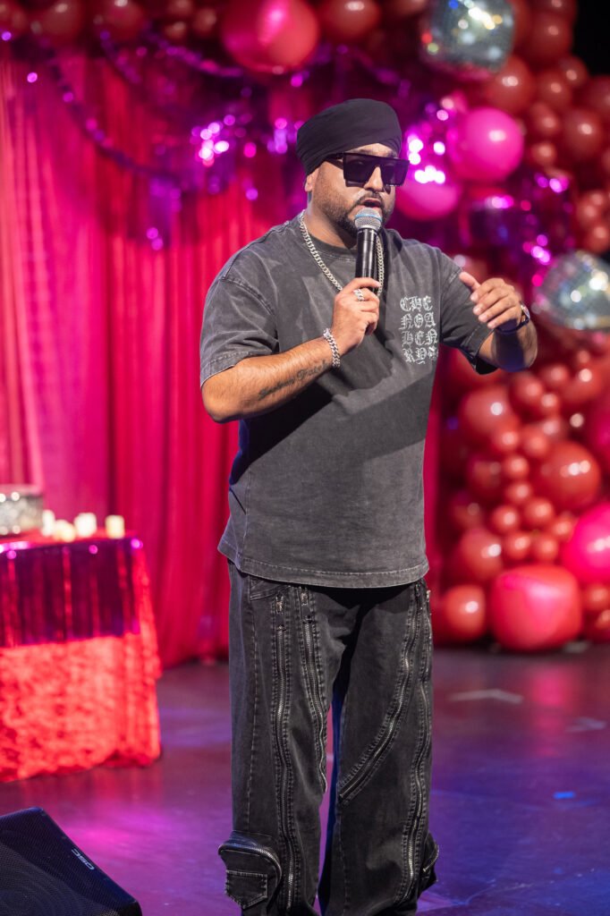 Manj Musik on stage Pittsburgh — performer in black turban on red stage at milestone birthday event