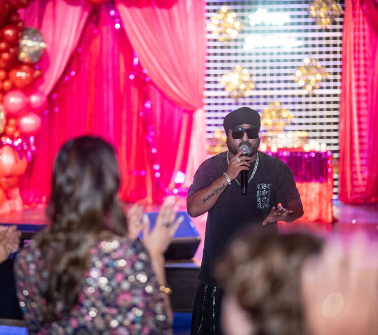 Manj Musik live performance Pittsburgh — singer with mic on red draped stage at luxury 40th birthday