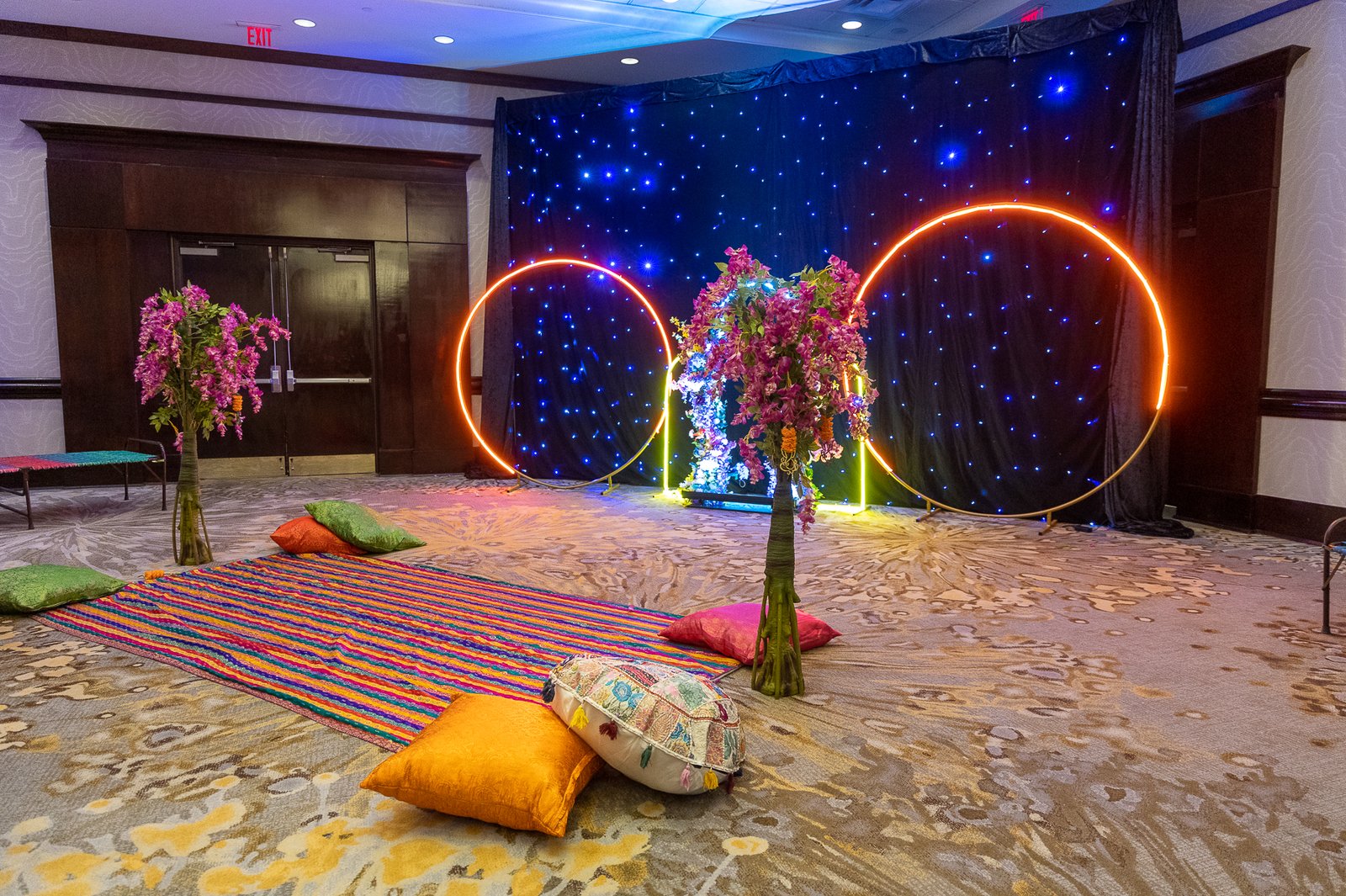 Modern sangeet stage by Regal Event Decor — neon arches, starry backdrop and colorful floor seating, fusion wedding decor New Jersey