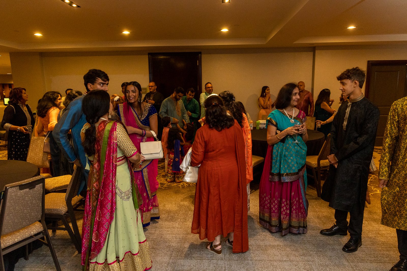 Sangeet ballroom wide shot by Regal Event Decor — purple uplighting, neon stage and festive decor, Indian wedding New Jersey